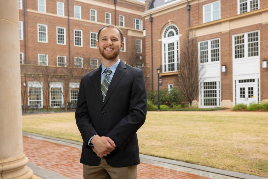 Logan Williamson in suit outdoors in plaza