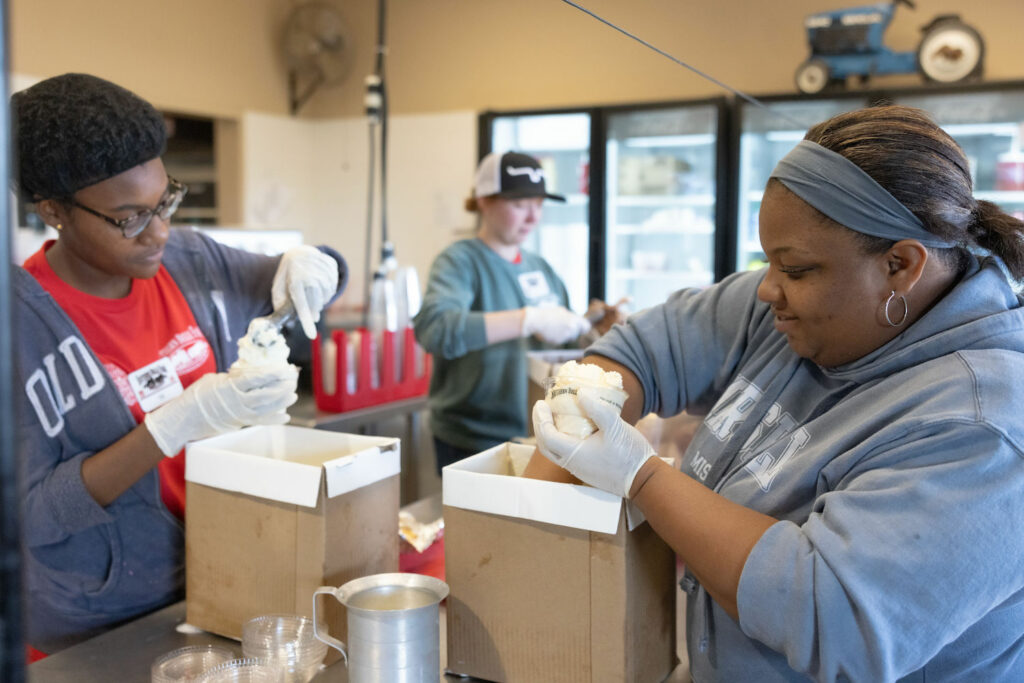 workers packing cups of ice cream