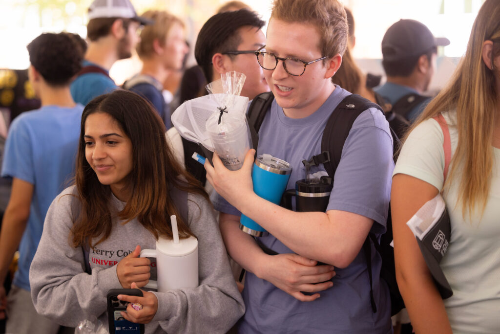 Students carry an armful of Terry swag items  leader at the Terry College Back to Business resource fair. 
