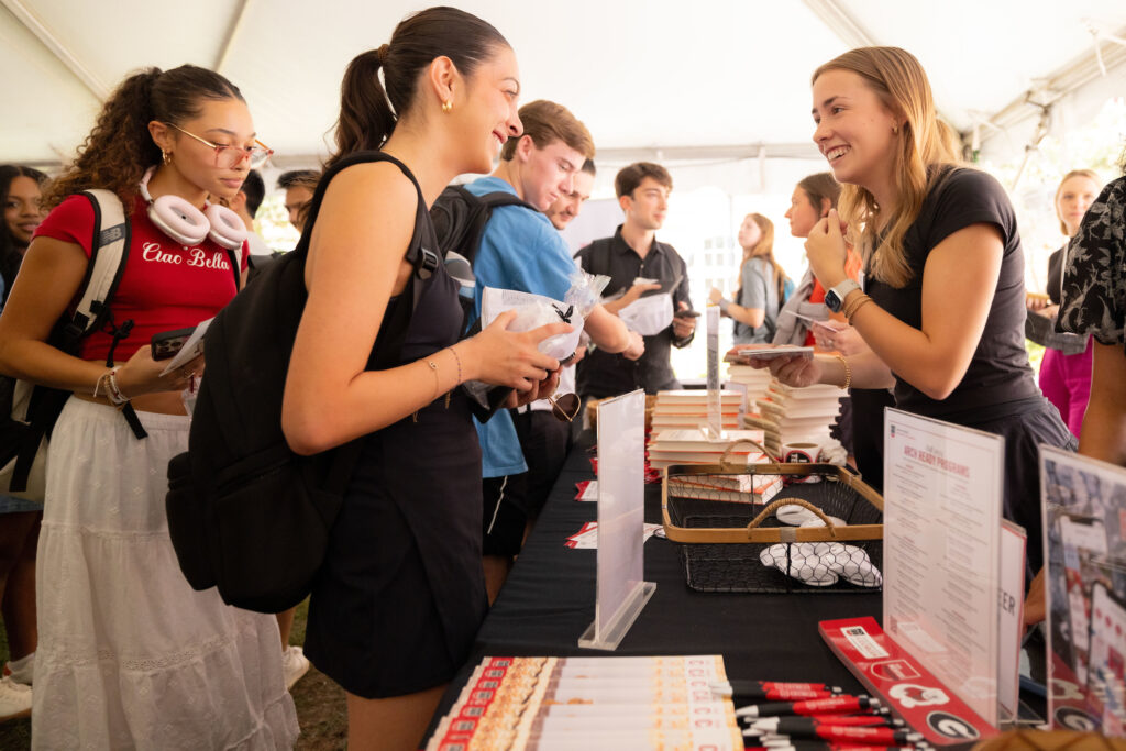 Students talk to a student organization leader at the Terry College Back to Business resource fair. 