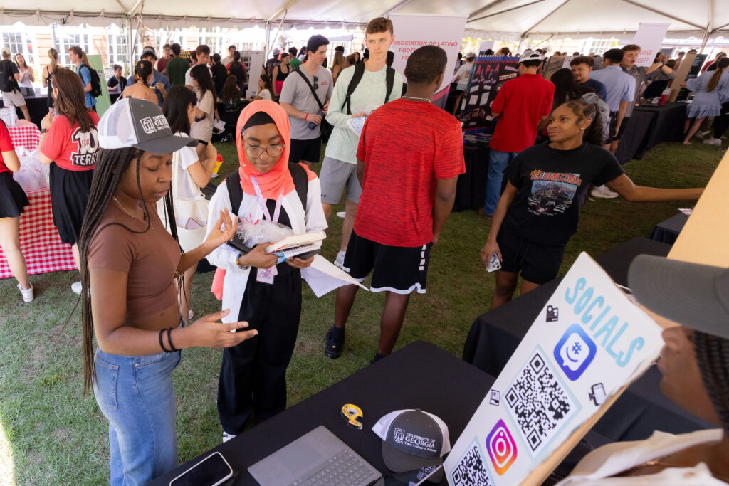 Students scan a QR code for more information at a Back to Business student resource fair at Terry College's Business Learning Community. 