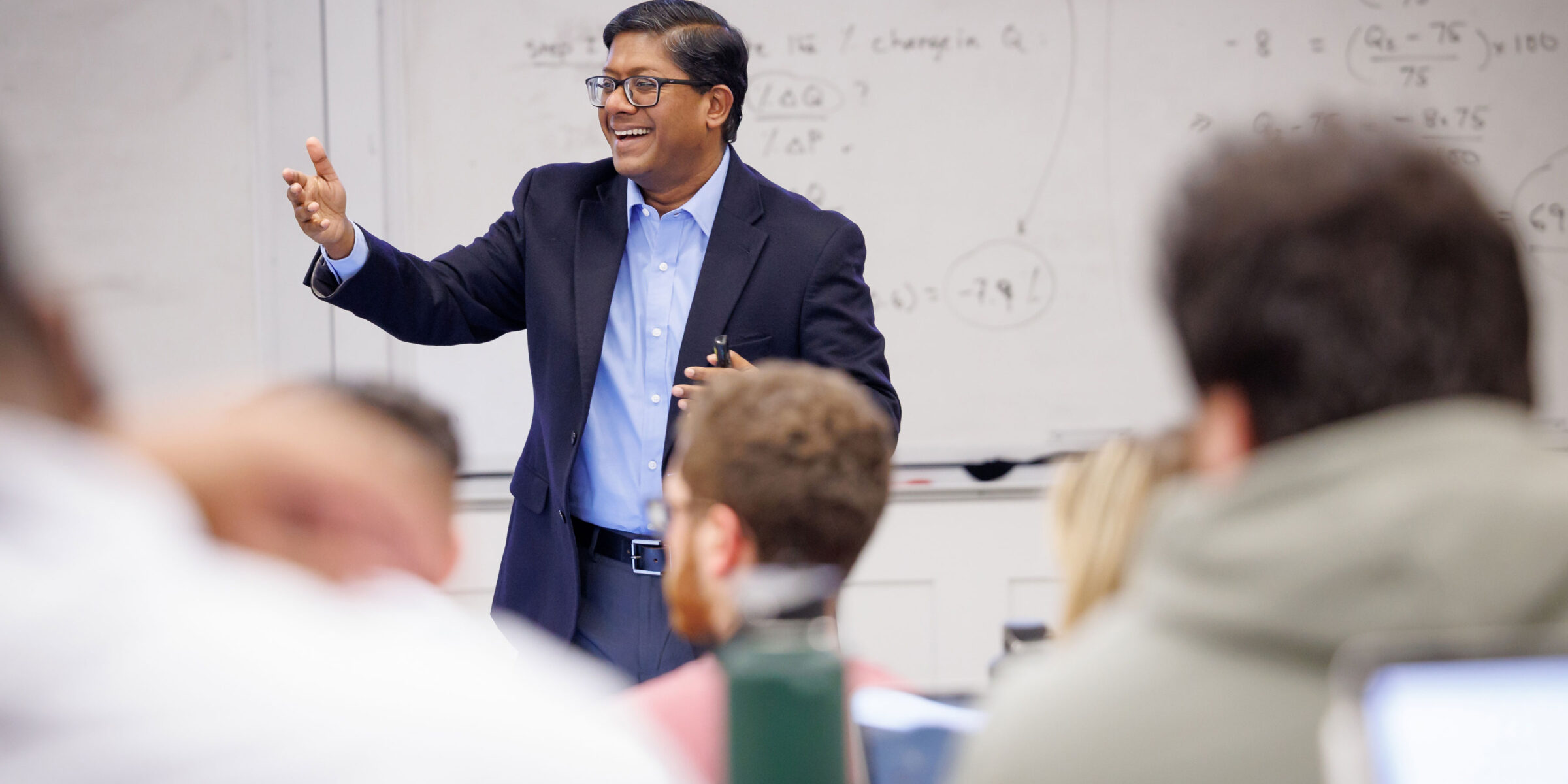 A professor, Dr. Santanu Chatterjee, happily giving a lecture to an engaged audience