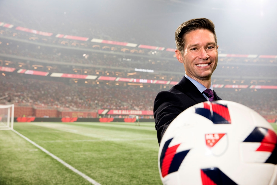 Dan Courtemanche holds a soccer ball on the sidelines of a Major League Soccer game at Mercedes-Benz Stadium in Atlanta.