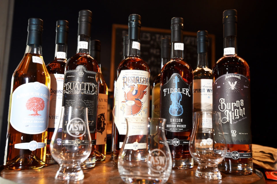 ASW Distillery whiskey bottles are displayed with company-branded glasses.