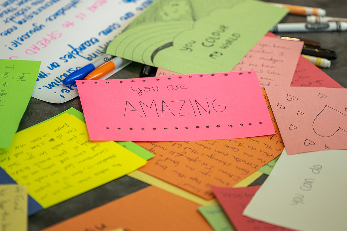 A stack encouraging notes that students wrote to pack in backpacks for homeless people
