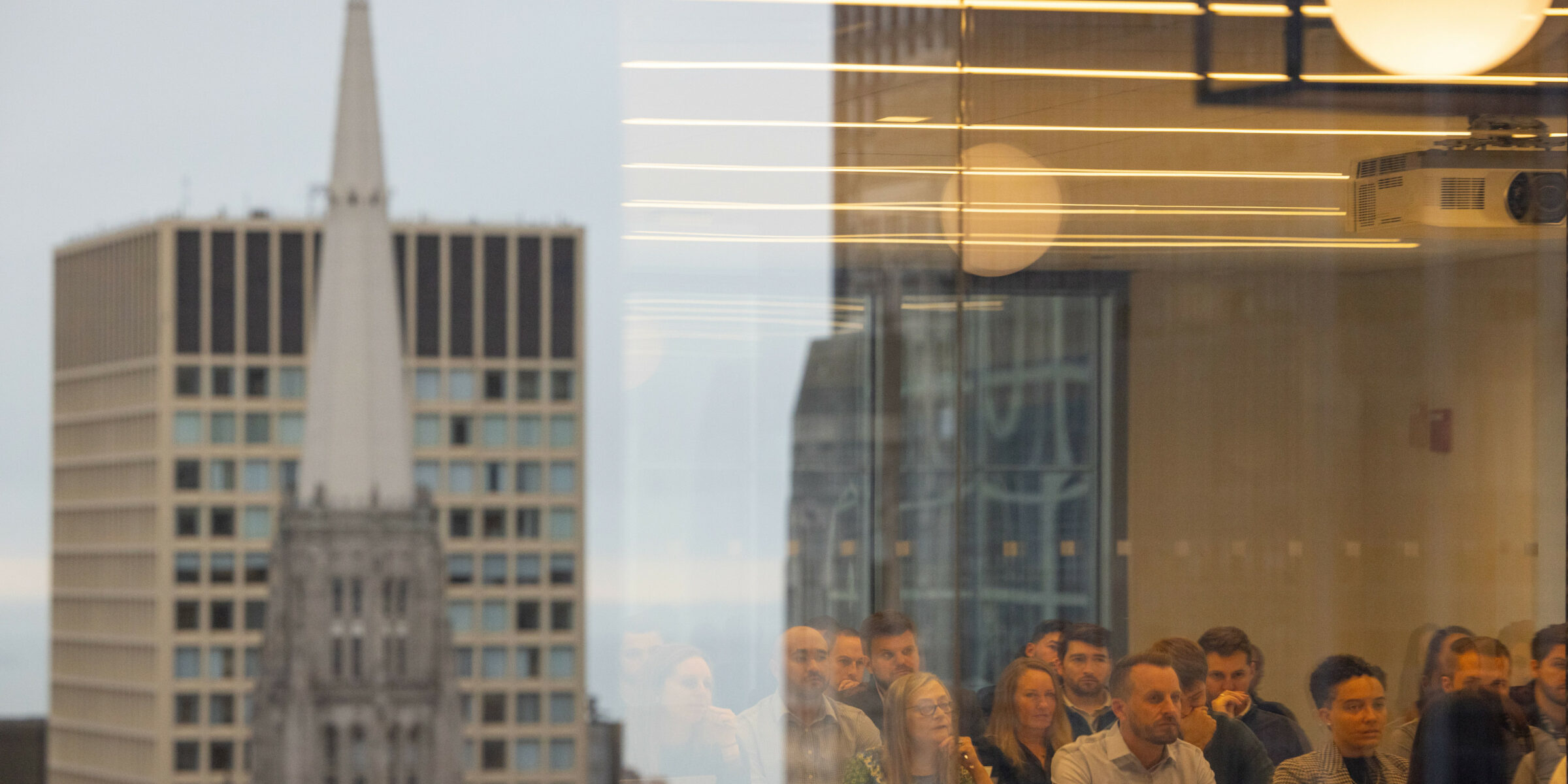 With the Chicago skyline reflected in a window, a group of Terry MBA students sit in the Chicago Bears’ business offices in downtown Chicago during a domestic residency program.