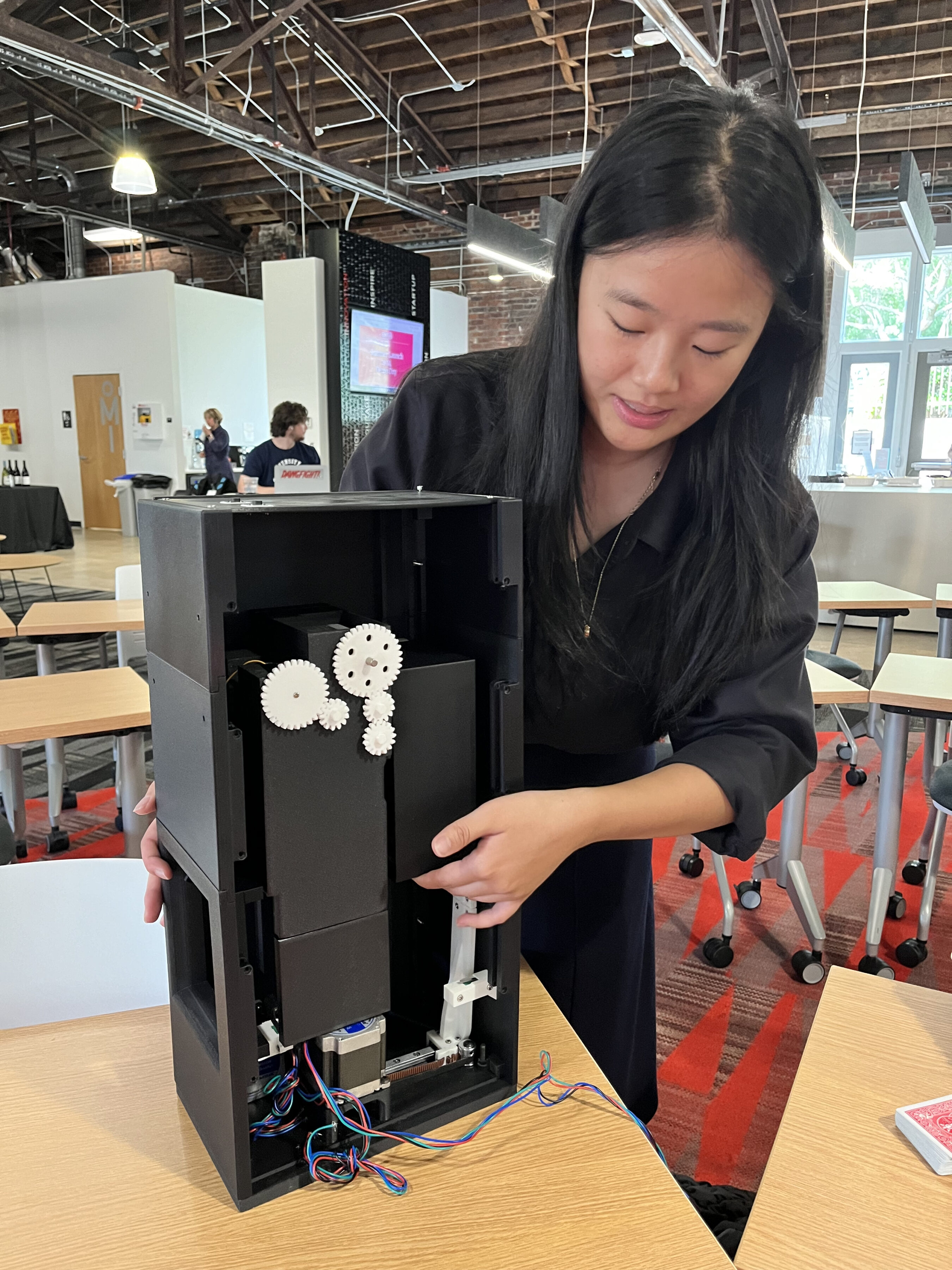 A girl showing off Moontrace, a card shuffler for card trading. 