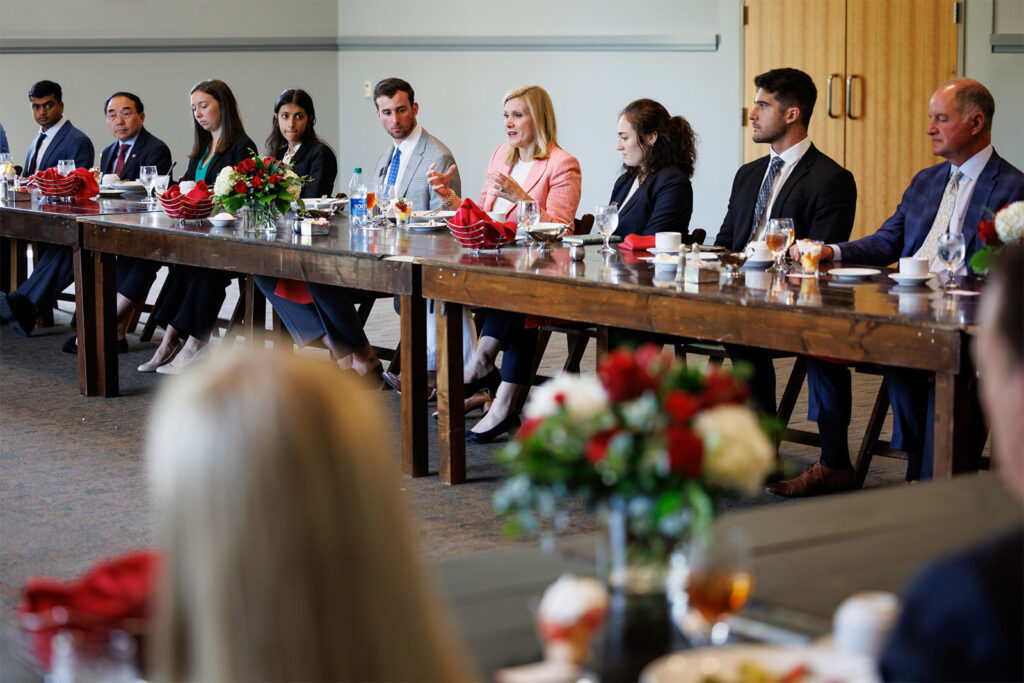Donna Hyland, in center of a long table, during a roundtable before the Mason Public Leadership Lecture
