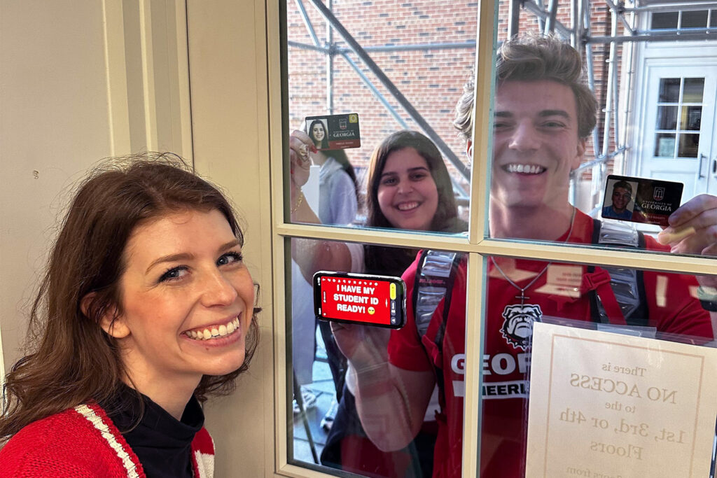 Students wait in line behind a glass door waiting to see Megan Moroney speak. 