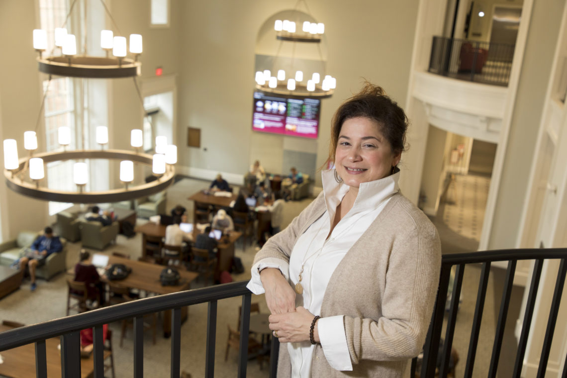 Associate professor Marie Mitchell stands along the railing above the Casey Commons inside Amos Hall in the Terry College Business Learning Community.