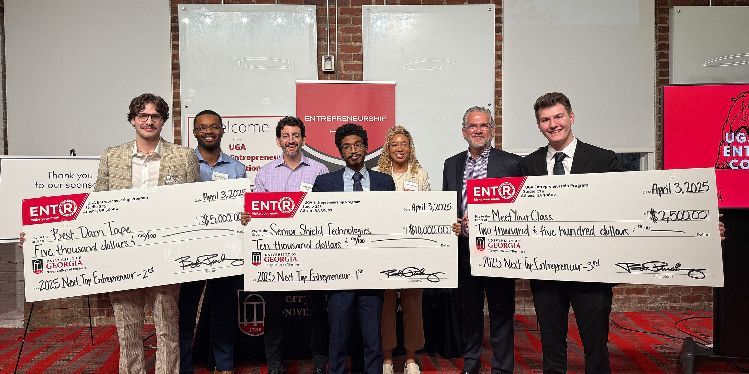 Winners of the Next Top Entrepreneurship Program pose with novelty checks