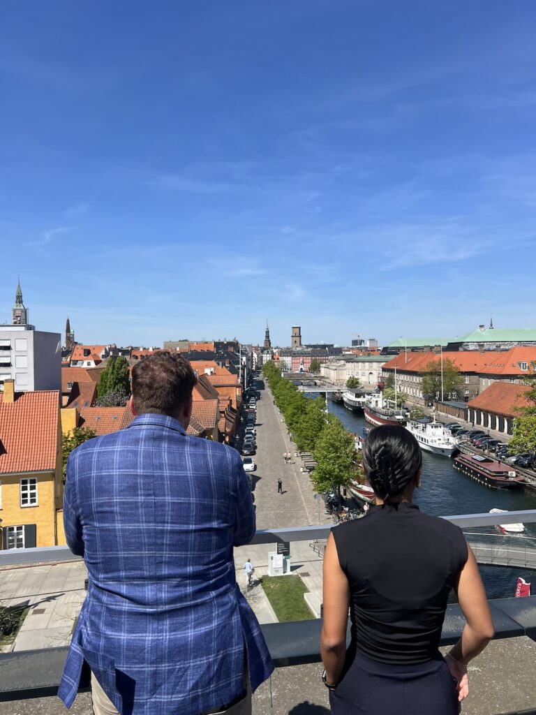 ScandiClassBusinessSightSeeing Two UGA students stare out onto a Scandinavian city scape dressed in business clothes during a study away course in Northern Europe.