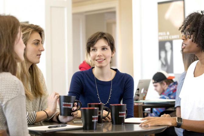 Kyla Sterling talks with students at a table.